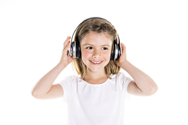 Portrait of a cute 7 years old girl Isolated over white background with headphone - Foto, imagen