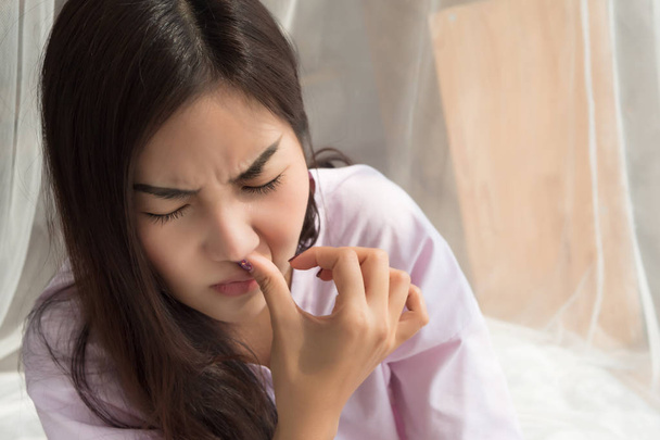 sick girl sniffle with runny nose; sick woman suffering from cold, flu, runny nose, trying to clear her nose; woman personal health care, sinus pain, sickness concept; asian young adult woman model - Photo, Image