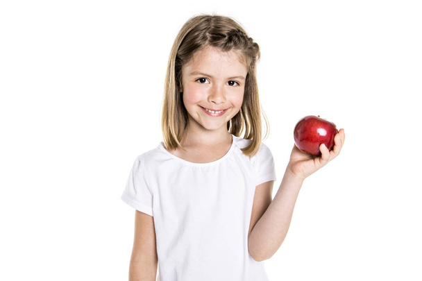 Portrait of a cute 7 years old girl Isolated over white background with apple - Zdjęcie, obraz