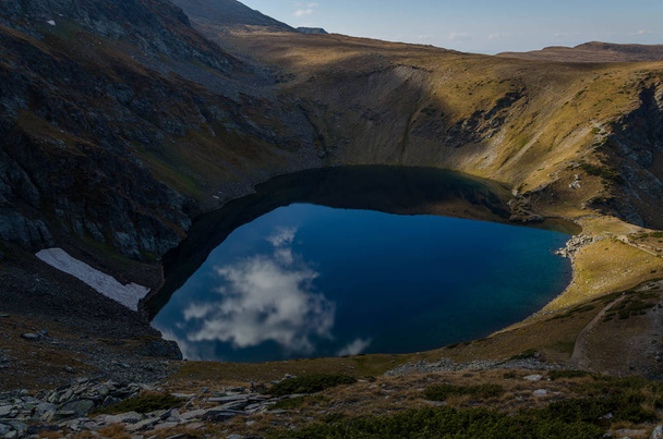 Vue sur le lac Okoto (The Eye), un des lacs glaciaires du nord-ouest des monts Rila. Miroir soufflant comme des reflets de lac en Bulgarie. Automne 2018
  - Photo, image