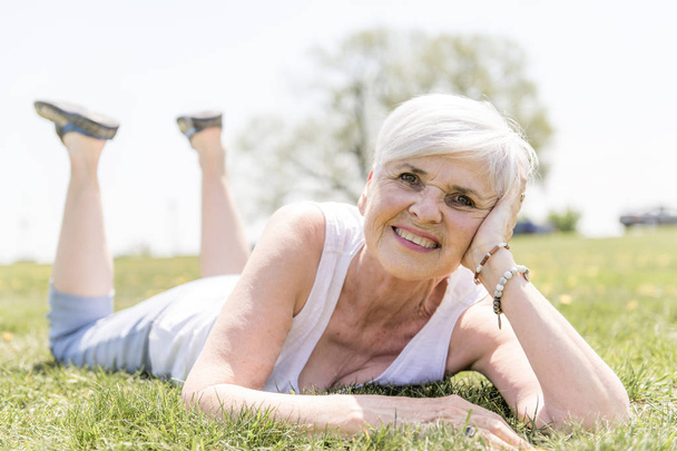 Active and happy senior woman outside in summer season - Valokuva, kuva