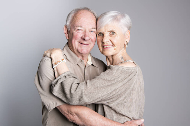 Senior couple posing on studio gray background - Фото, зображення