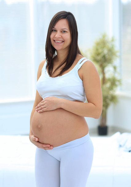 portrait of young pregnant woman on a light background. - Zdjęcie, obraz