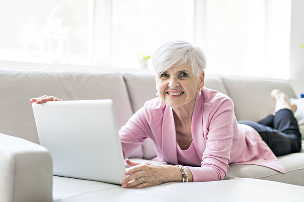 Retired senior woman sitting at home using her laptop - Fotografie, Obrázek