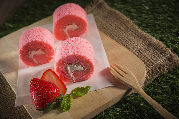Pink colored rolled cakes with wooden fork on chalkboard - Fotoğraf, Görsel