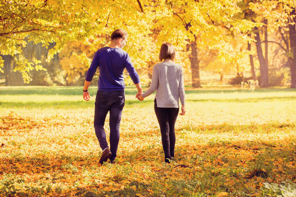 couple walking in autumn park - Φωτογραφία, εικόνα