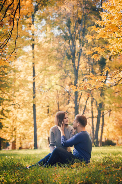 Young couple is sitting on the meadow - Foto, imagen