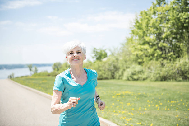 Senior Woman Jogging In Park - Foto, Bild