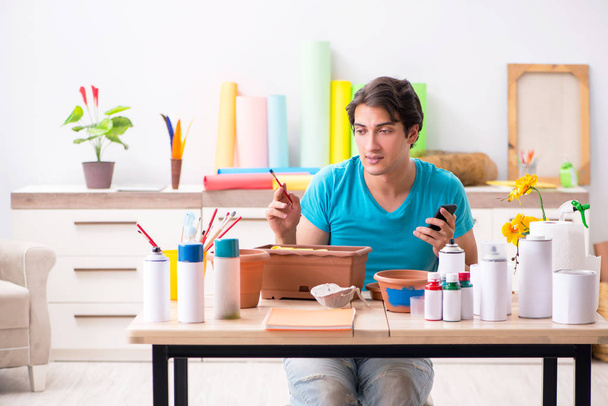 Young man decorating pottery in class - Zdjęcie, obraz