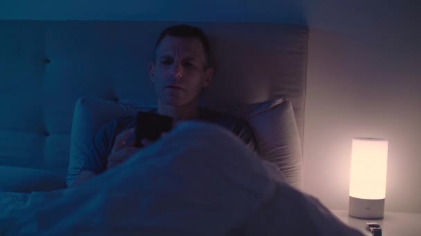 Man goes to sleep after putting down his smartphone - Filmmaterial, Video