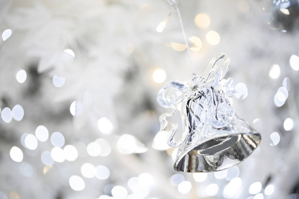 silver christmas bell decoration on blurred sparkling holiday background - Photo, image
