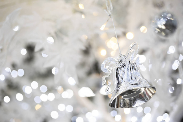 silver christmas bell decoration on blurred sparkling holiday background - Photo, image