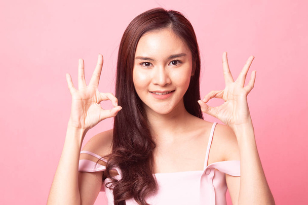 Asian woman show double OK hand sign  and smile on pink background - Фото, изображение