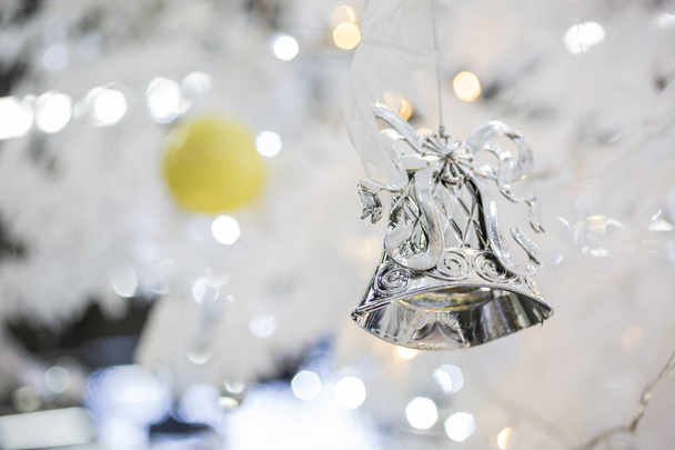 silver christmas bell decoration on blurred sparkling holiday background - Foto, Bild