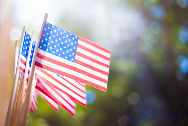 Miniature paper flags USA. American Flag on blurred background outdoors - Zdjęcie, obraz