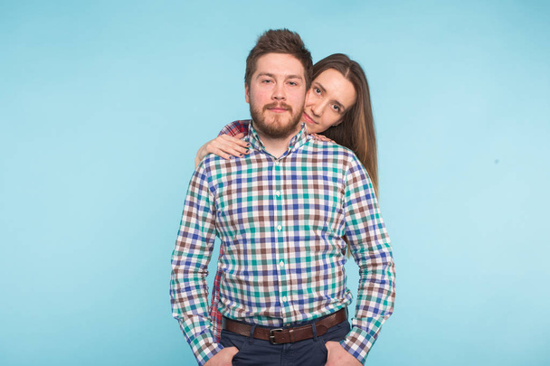 Portrait of cheerful funny young lovers on blue background - Photo, Image