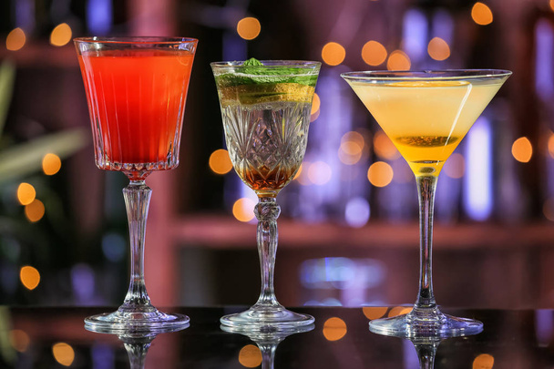 Fresh summer cocktails in glasses on table against blurred lights - Photo, Image