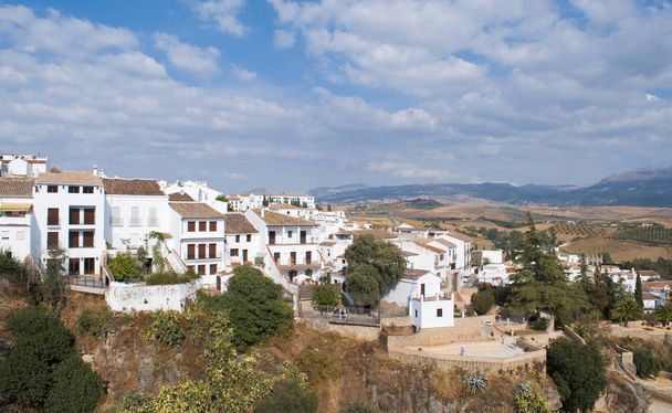 Casas blancas situadas una al lado de la otra en el pueblo de Ronda en Málaga, España, son casas encaramadas en una montaña empinada a gran altitud, es un cielo con nubes por encima
  - Foto, Imagen