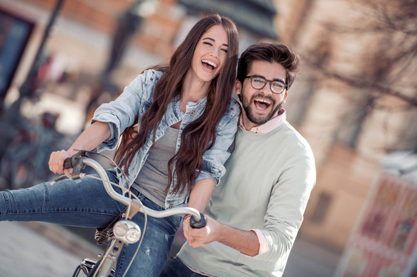 Jeune couple à vélo et s'amuser en ville
 - Photo, image