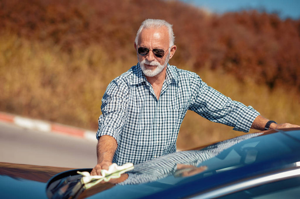 Senior man cleaning car on open air - Zdjęcie, obraz