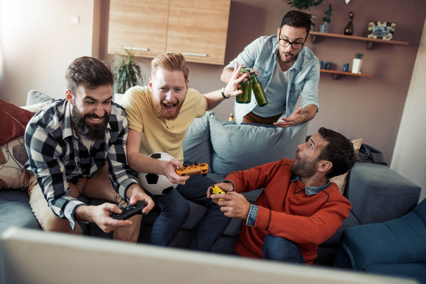 Felice amici maschi divertirsi a casa, guardando il calcio in TV
 - Foto, immagini