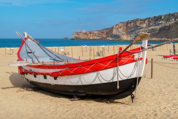 Traditional portuguese fishing boat on the beach. Nazare, Portugal - Photo, Image