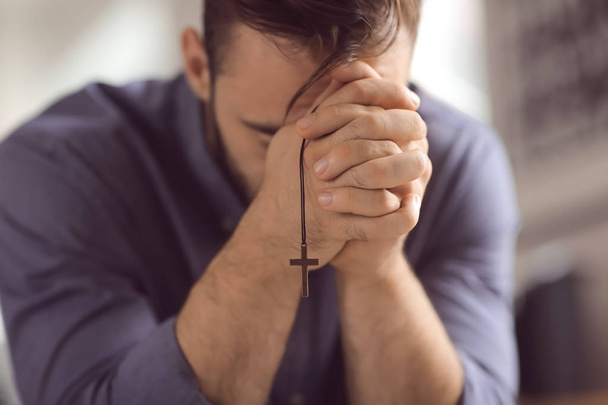 Religious young man praying to God at home, closeup - Foto, Imagem