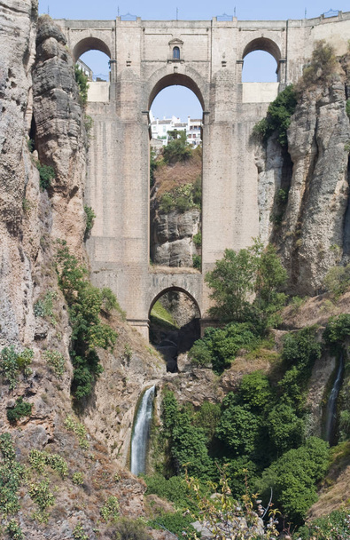 Puente romano de cuatro arcos situado en la localidad de Ronda en la provincia española de Málaga. Está en el puerto en medio de un acantilado rocoso rodeado de vegetación y una cascada en el centro
.  - Foto, Imagen