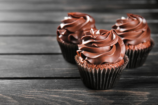 Delicious chocolate cupcakes on wooden table - Φωτογραφία, εικόνα