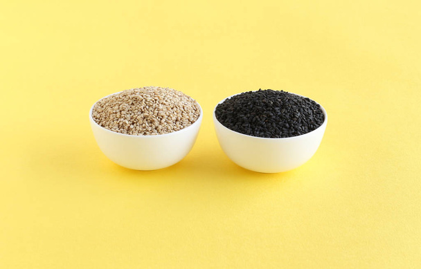 Alimento saludable semillas de sésamo blancas y negras, ricas en nutrientes esenciales y alto contenido de aceite, en tazones
. - Foto, Imagen