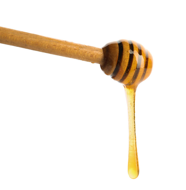 Honey dripping from dipper on white background - Fotografie, Obrázek