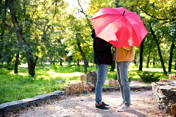 glückliches homosexuelles Paar mit Regenschirm im Park - Foto, Bild