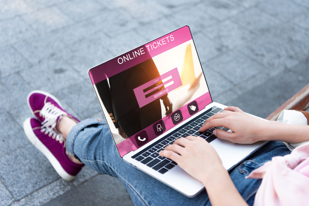 imagem cortada de mulher usando laptop com aparelho de bilhetes on-line na rua
 - Foto, Imagem