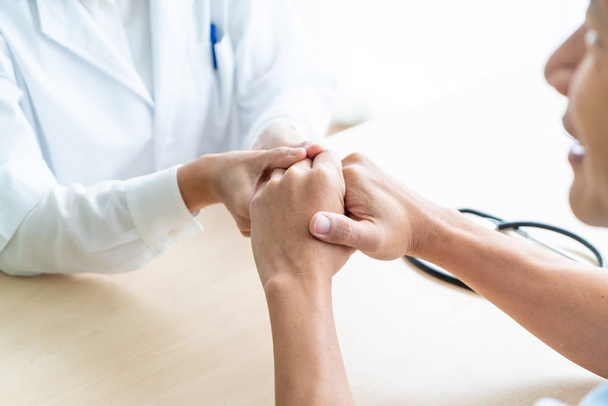 Hand of female doctor holding on her senior patient - selective focus point - 写真・画像
