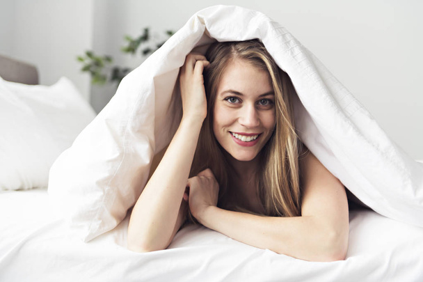 Beautiful young woman on bed, 20s year old - Фото, зображення