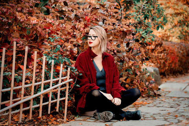 Stylish woman in red shirt in park. Autumn season time  - Foto, Bild