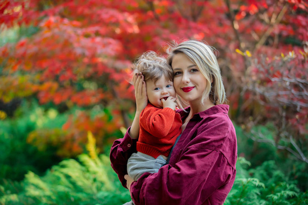 Young mother with baby boy in park. Autumn season time - Photo, Image