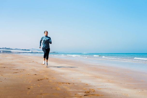 Vrouw draait op het strand, buiten training - Foto, afbeelding