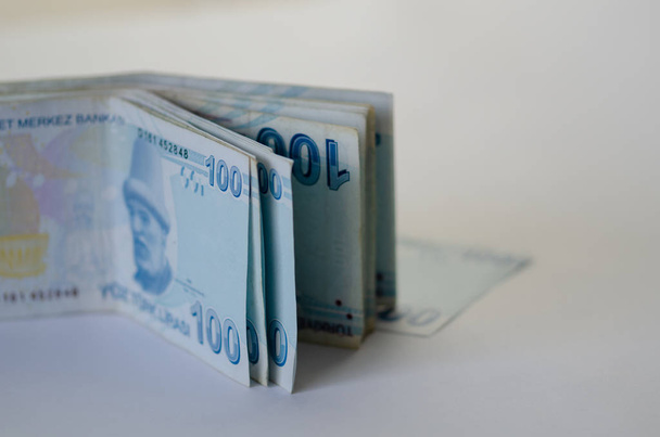 Εκατό τουρκικές λύρας banknots σε λευκό φόντο με αντίγραφο χώρου. - Φωτογραφία, εικόνα