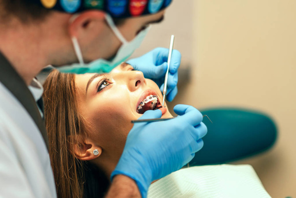 Dentist examine female patient with braces in denal office - Foto, Imagem