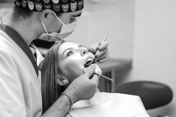 Dentist examine female patient with braces in denal office - Foto, immagini