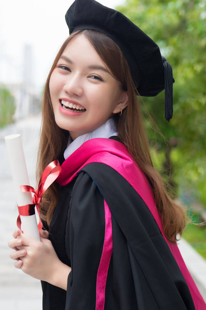 幸せな笑顔の女子大生卒業;卒業生や大学の女性学生の肖像画,教育の概念;アジアの20代の若い大人の女性モデル - 写真・画像
