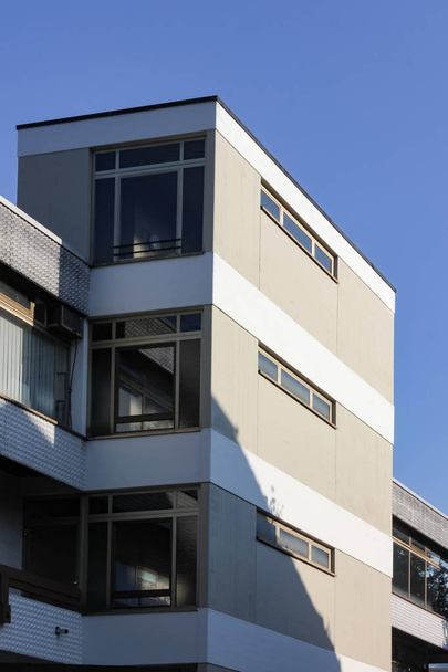 Fassade eines Bürogebäudes mit blauem Himmel und Fenstern - Foto, Bild