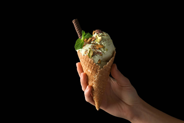 Woman holding waffle cone with delicious ice cream on dark background - Fotografie, Obrázek