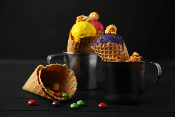 Conos de gofre con delicioso helado de color en copas de metal sobre mesa de madera
 - Foto, imagen