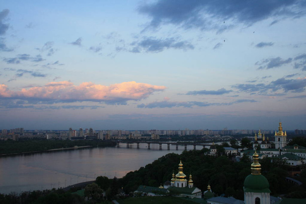 Kiev Pechersk Lavra on hill of Dnieper river on background at sunrise - Photo, Image