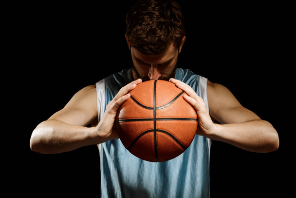 Focused man holding a basketball - 写真・画像