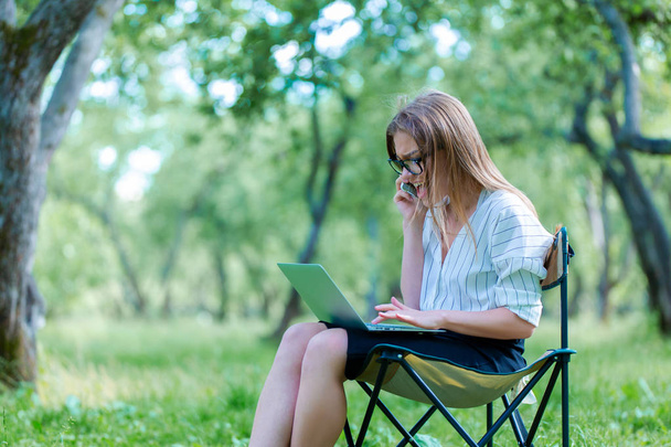 Girl using laptop on lunch break in city park - Fotoğraf, Görsel