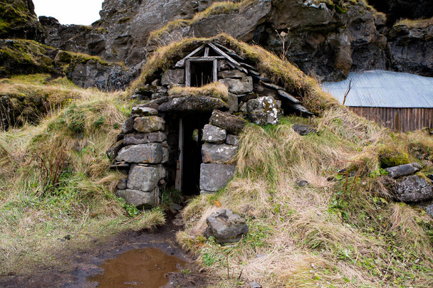 Типичные икеландские дома, покрытые травой. Исландские дома, покрытые травой и скалами на заднем плане. красивые скандинавские дома
. - Фото, изображение