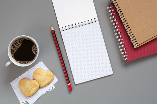 Ноутбук, карандаш и чашка кофе с печеньем в форме слуха
 - Фото, изображение